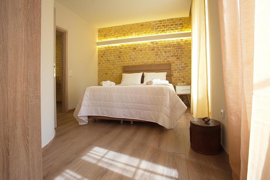 - une chambre avec un lit et un mur en briques dans l'établissement Liston Inn Suites(Plaza) - Heart of Corfu Old Town, à Corfou