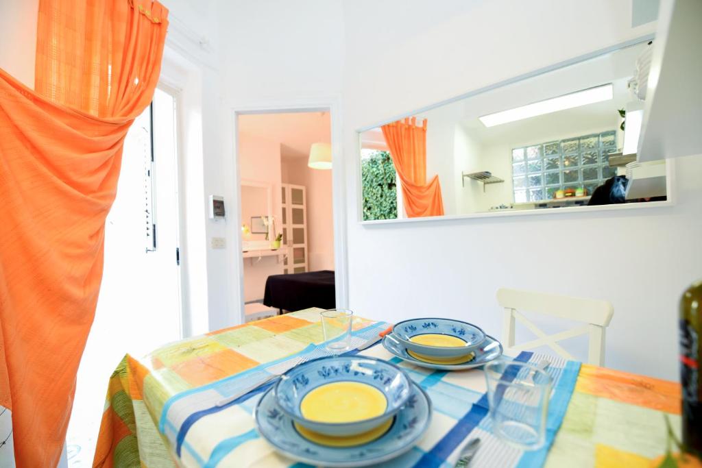 a table with two blue and yellow dishes on it at Le Querce in Procida