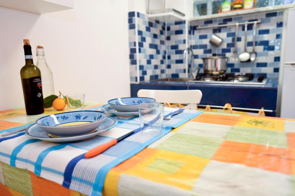 a table with two plates and a bottle of wine at Le Querce in Procida