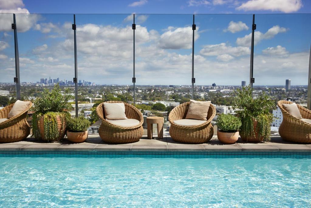 a swimming pool with chairs and plants on a building at 1 Hotel West Hollywood in Los Angeles