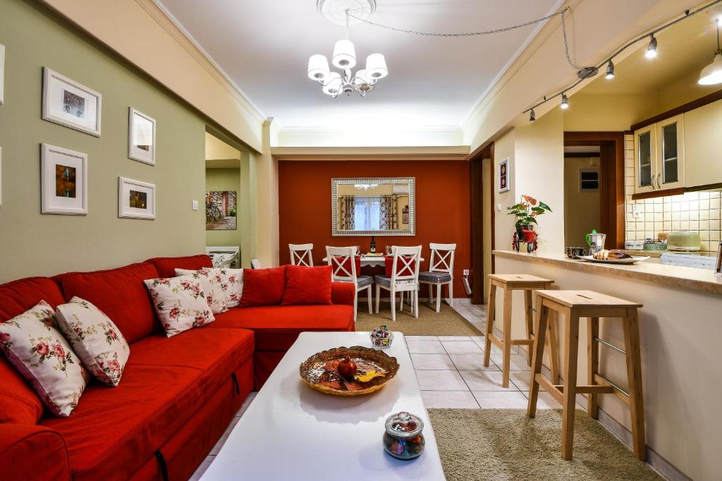 uma sala de estar com um sofá vermelho e uma cozinha em Star Parthenon Apartment em Atenas