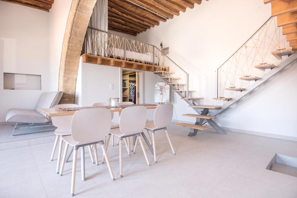 une salle à manger avec une table en bois et des chaises blanches dans l'établissement Villa Acacia, à Fánai
