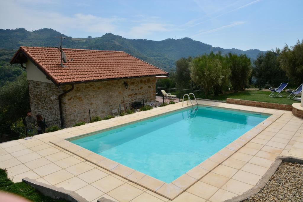 a large swimming pool in front of a house at Casa Delle Olive in Dolceacqua