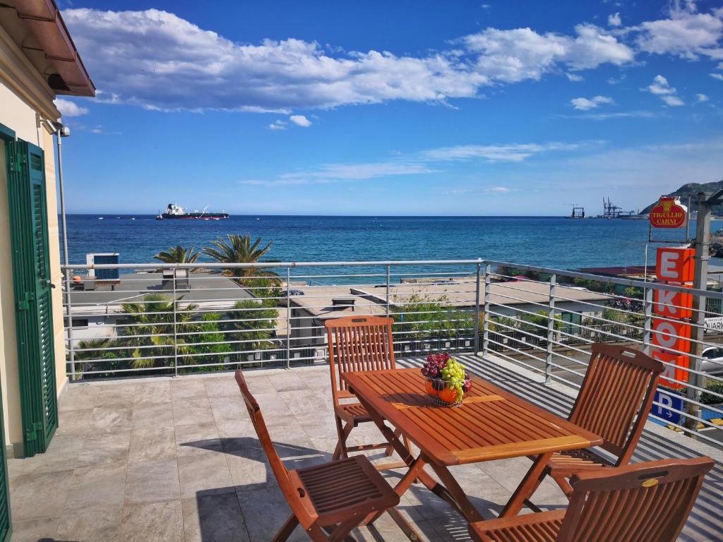 a table and chairs on a balcony overlooking the ocean at Appartamento deluxe con terrazza sul mare in Savona