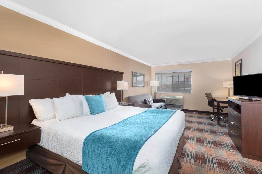 a hotel room with a large bed and a desk at Inn at Moses Lake with Extended Stay in Moses Lake