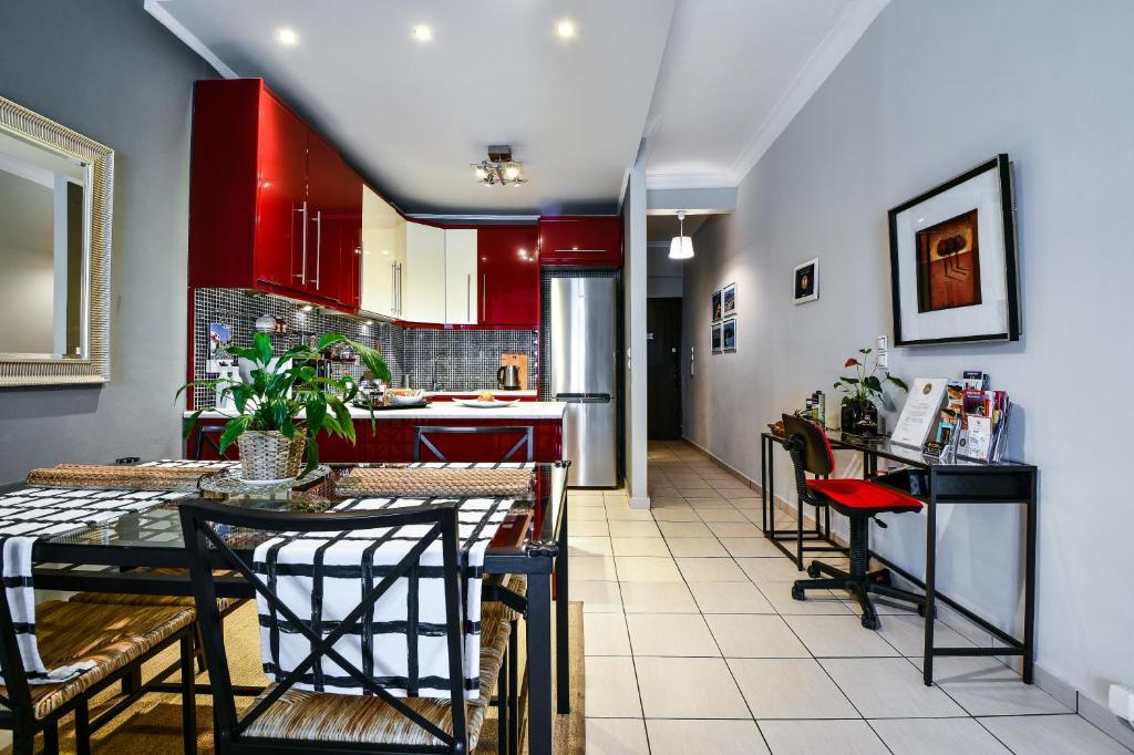 a kitchen with red cabinets and a table and chairs at Star Acropolis Apartment in Athens