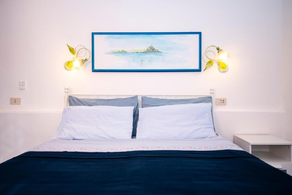 a bedroom with a blue bed with a picture above it at Le Querce in Procida