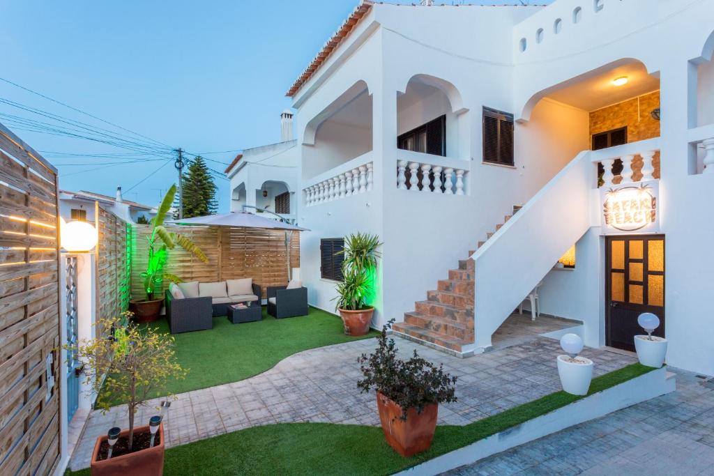 a white house with a lawn in the yard at Safari Beach guest house in Lagos