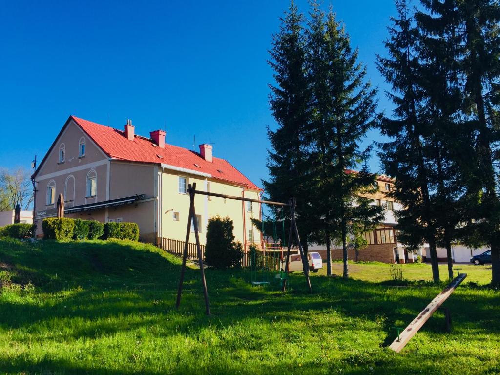 a house with a yard with a swing at Pension Žacléřský Medvěd in Žacléř