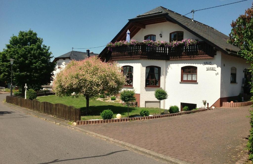 a white house with a balcony on a street at Haus Bärbel in Geisfeld