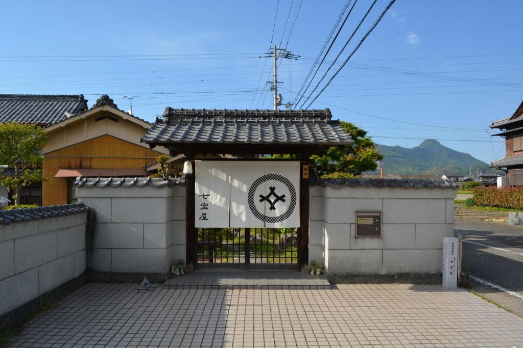 ein Tor zu einem Gebäude mit einem Schild darauf in der Unterkunft BED N CHILL Shippoya 七宝屋 in Mitoyo