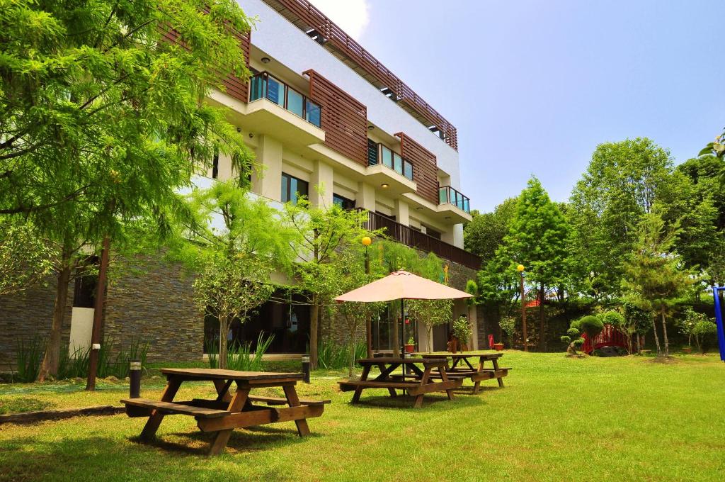 a group of picnic tables in front of a building at One City One Vacation Farm in Nantou City