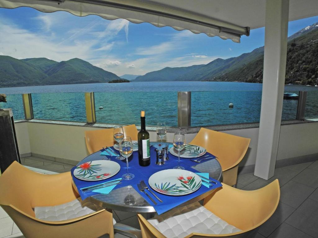 a dining table with a view of the water at Residenza Acapulco App 1977 in Ronco sopra Ascona