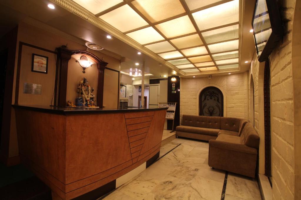 a lobby with a bar and a couch in it at Hotel Shivkrupa in Pune