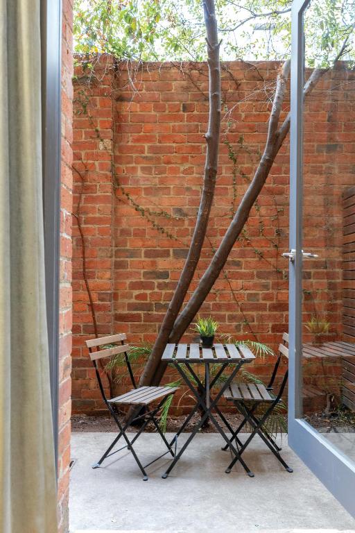 a table and chairs in front of a brick wall at Best Western Melbourne City in Melbourne