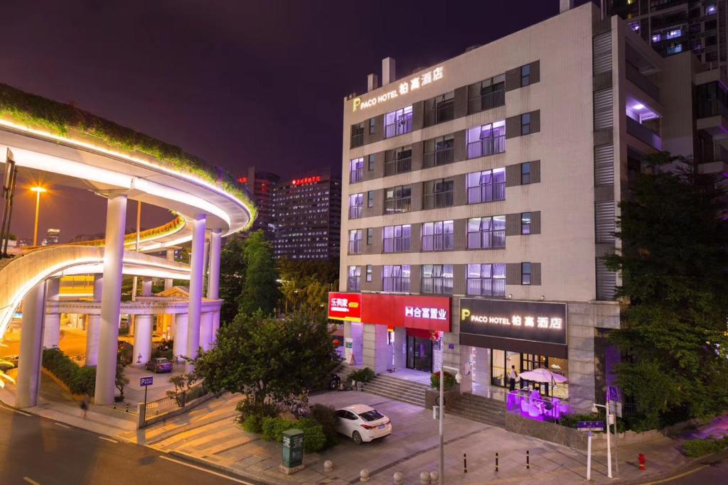 un bâtiment avec une voiture garée devant dans l'établissement Paco Hotel Zhujiang New Town Jinan University Guangzhou-Free Shuttle Bus for Canton Fair-Proximity to the Buyer Registration Center, à Canton