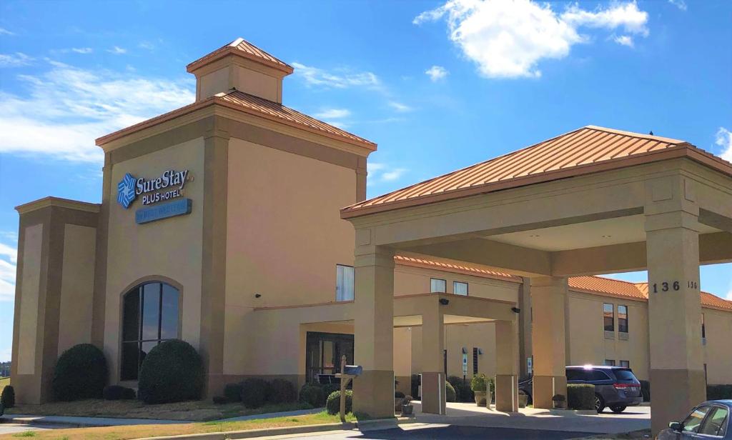 un bâtiment d'hôtel avec un panneau devant lui dans l'établissement SureStay Plus Hotel by Best Western Roanoke Rapids I-95, à Roanoke Rapids