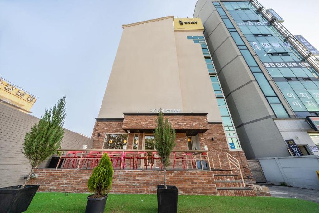 a building with palm trees in front of it at Chuncheon Bom Stay in Chuncheon