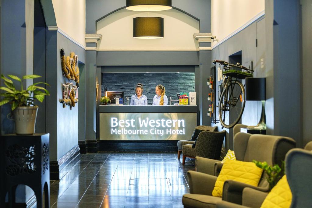 a lobby of a restaurant with two women behind a counter at Best Western Melbourne City in Melbourne