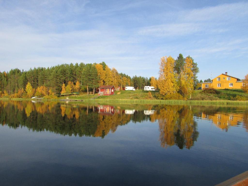 uitzicht op een meer met bomen en huizen bij Lemmenjoen Lumo - Nature Experience & Accommodation in Lemmenjoki
