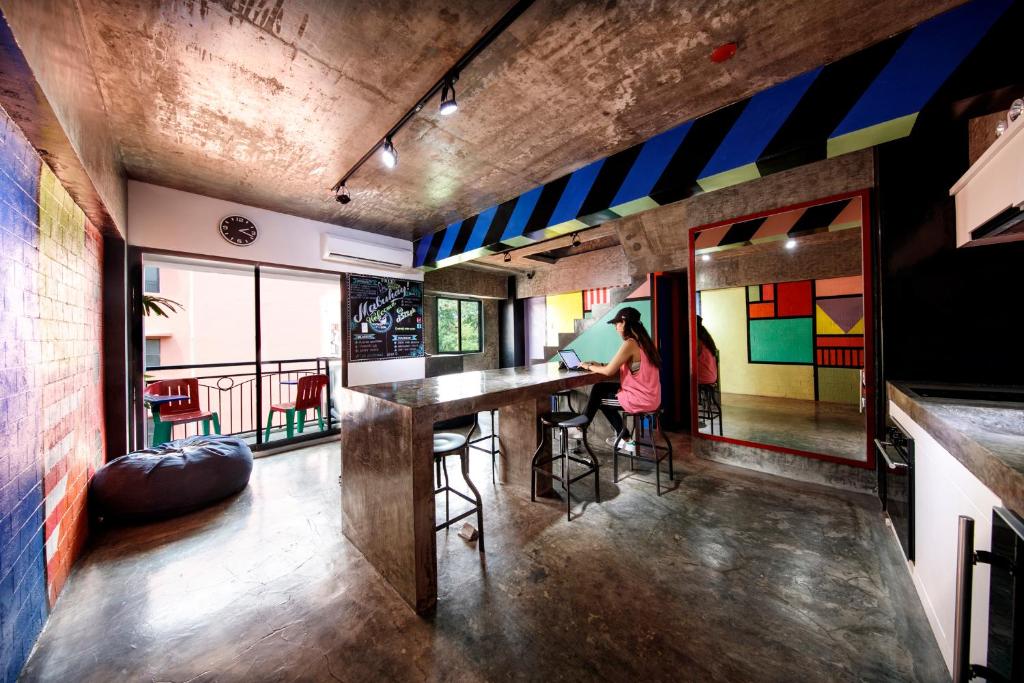 a woman sitting at a bar in a room with colorful walls at D522 Hostel at Kiener Hills - Near Cebu Airport in Mactan