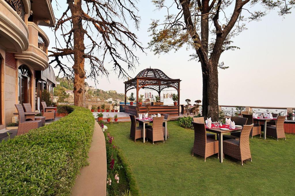 a gazebo with tables and chairs on the grass at Ramada by Wyndham Mussoorie Mall Road in Mussoorie
