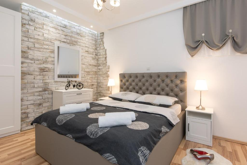 a bedroom with two beds and a brick wall at Pipo in Rijeka