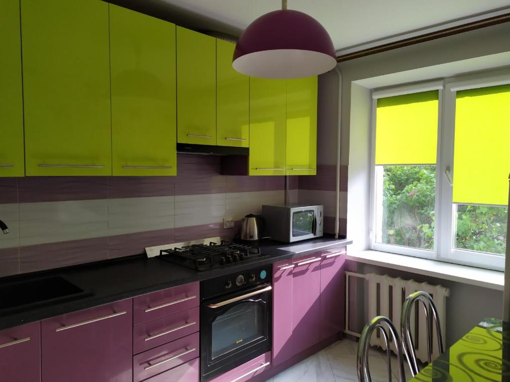 cocina con armarios rosados y verdes y fogones en Apartments near Arena on Syhivska en Leópolis