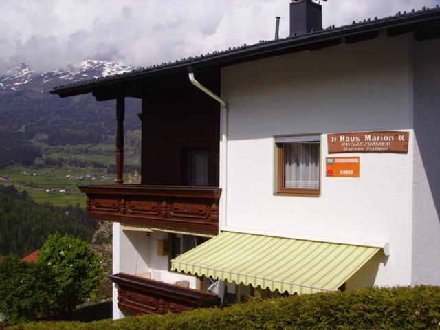 a white building with a balcony with a sign on it at Haus Marion in Jerzens