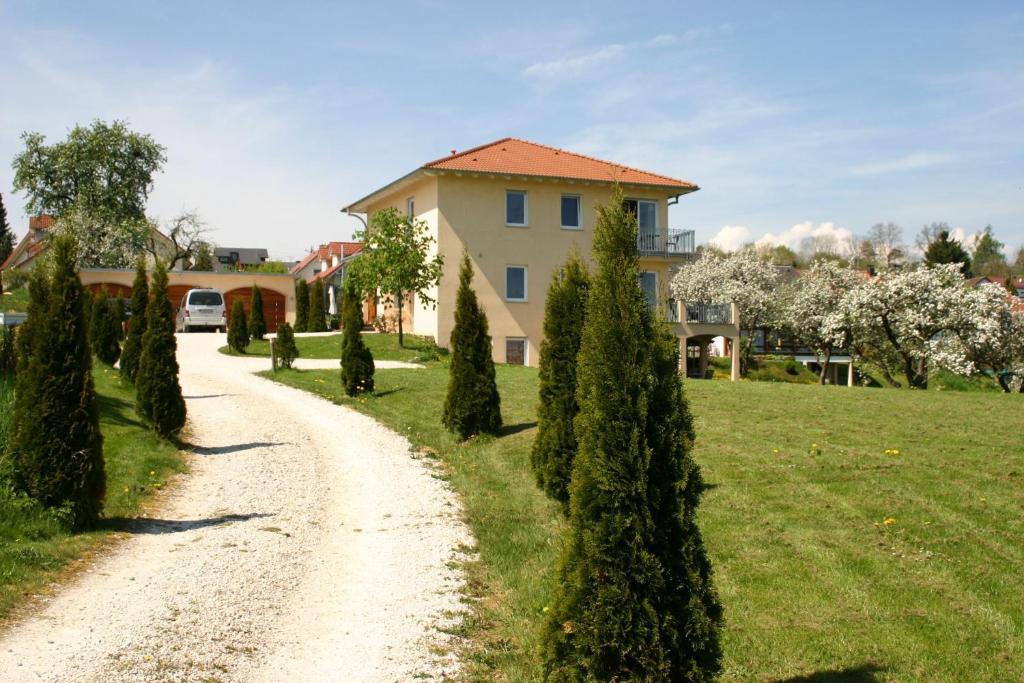 a dirt road in front of a house with trees at Villa Donautal in Inzigkofen