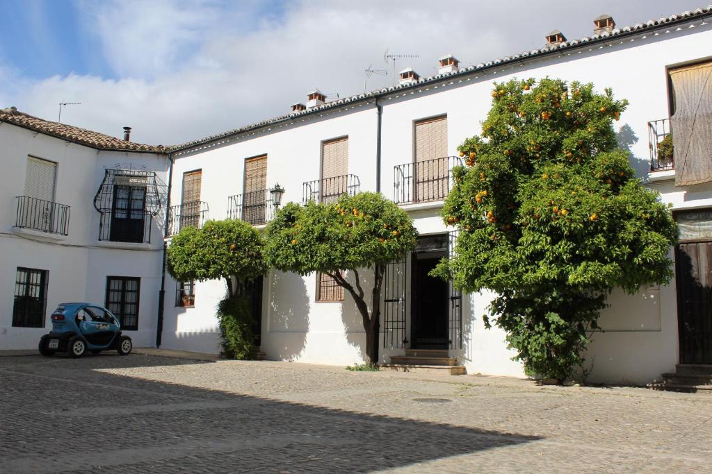 a small car parked in front of a white building at Casa Nieves in Ronda
