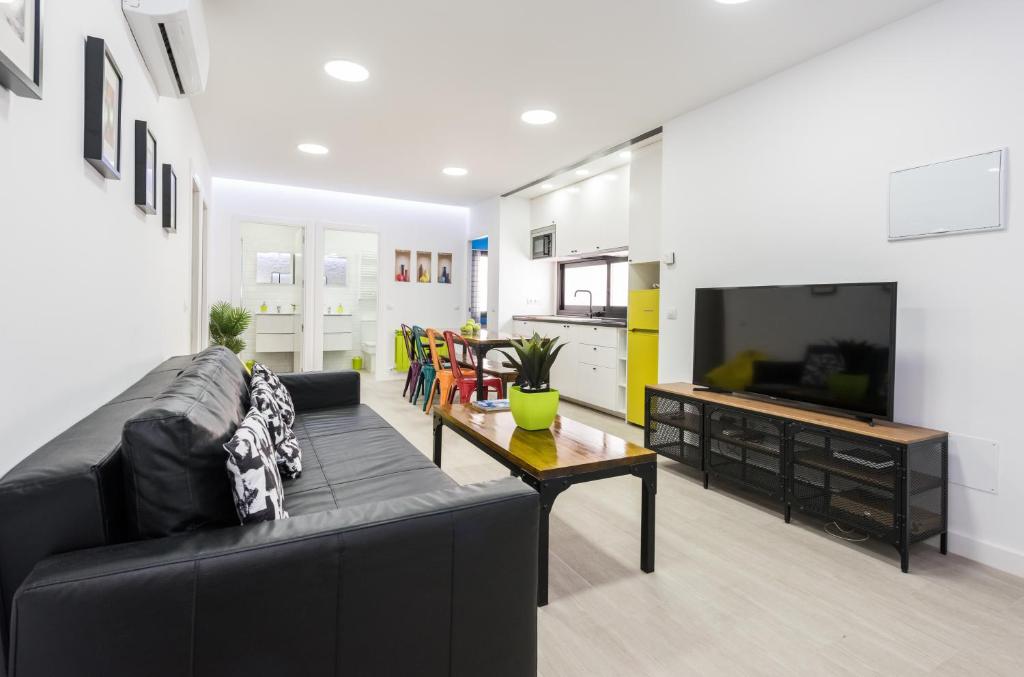 a living room with a black couch and a table at Ever House - ALCALA BRISA Gran TERRAZA ROOFTOP in Madrid