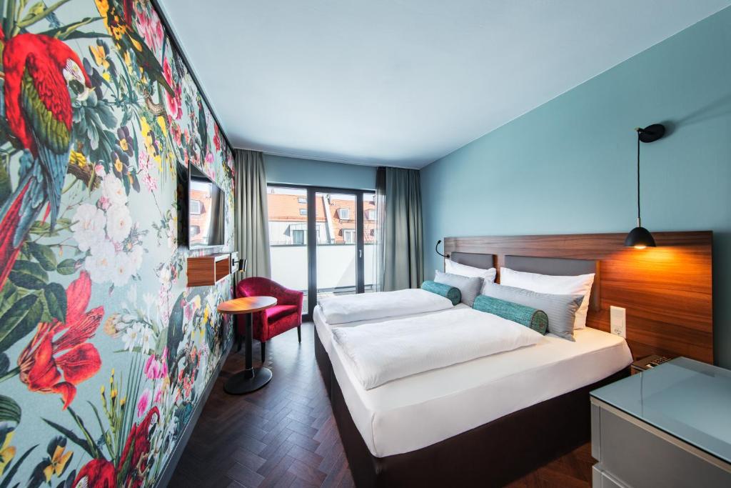 a bedroom with a large bed and a large window at Maison Schiller by DesignCity Hotels in Munich