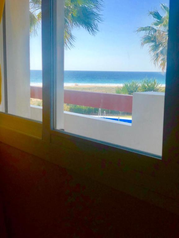 a window with a view of the beach at Apartasuites Royal Zahara, Máximo confort con vistas al mar in Zahara de los Atunes