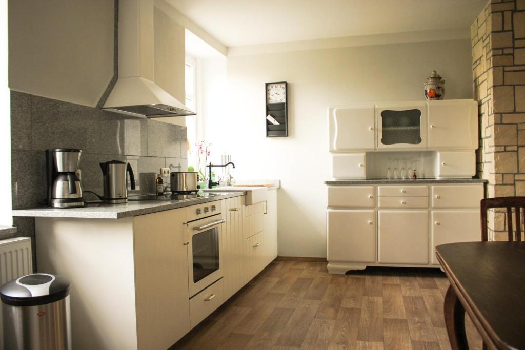 a small kitchen with white appliances and a table at Bauernhof Gerth in Göllnitz