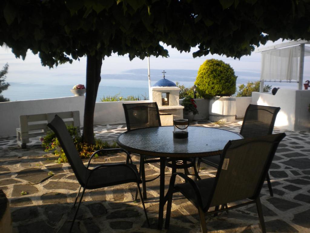 een tafel en stoelen met uitzicht op de oceaan bij Villa Olga studios in Nea Skioni