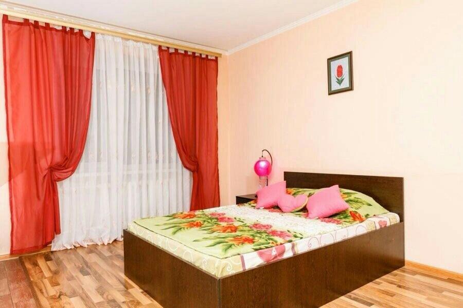 um quarto com uma cama com almofadas cor-de-rosa e uma janela em Борщаговская 202 Шулявская, Космополит, Большевик, ДК Росток, спорт комплекс Венето em Kiev