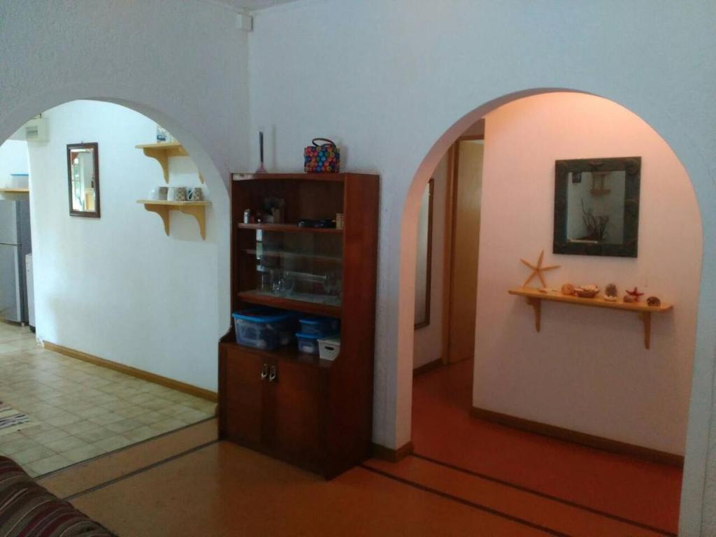 a living room with an archway and a room with a shelf at Villa Verde , haven of peace and love in Blue Bay