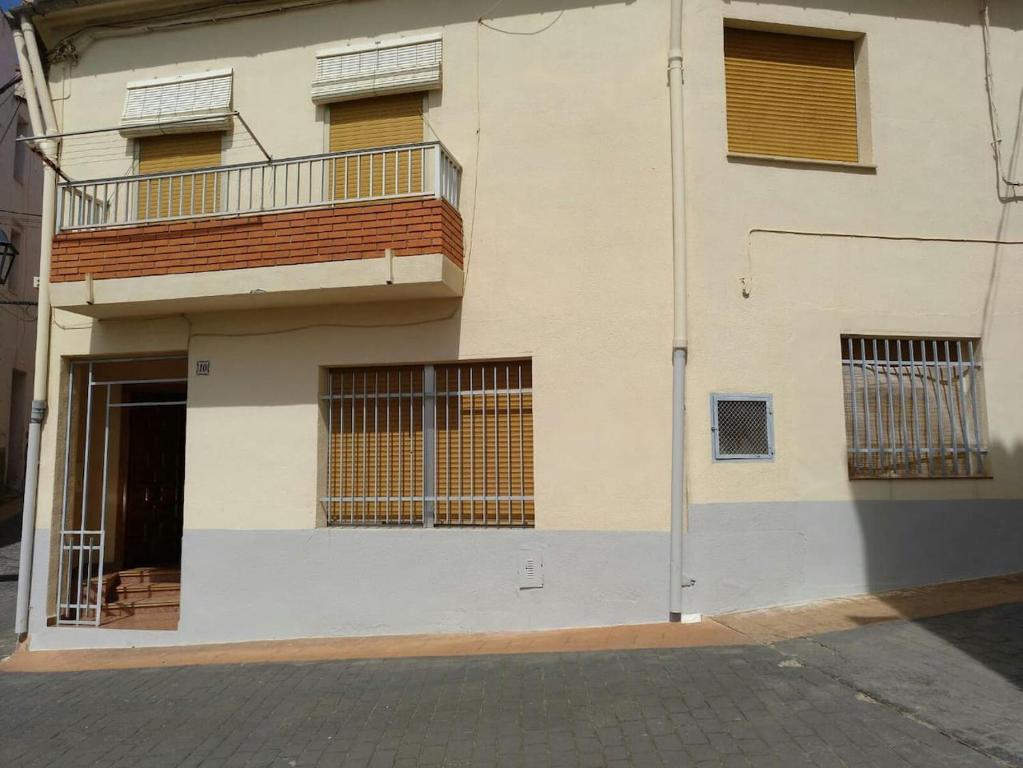 ein weißes Gebäude mit Fenstern und einem Balkon in der Unterkunft Casa Vall de Almonacid in Vall de Almonacid