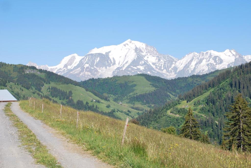 a dirt road with snow capped mountains in the background at LE MEGEVAN in La Giettaz