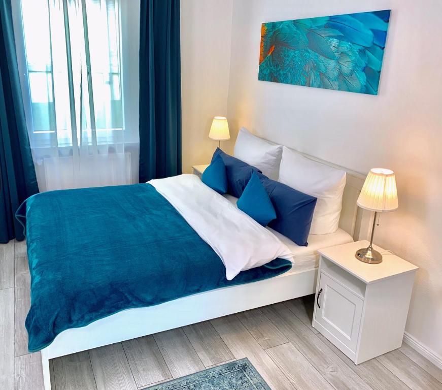 1 dormitorio con 1 cama grande con almohadas azules en Im kleinen Stil l, en Linz am Rhein