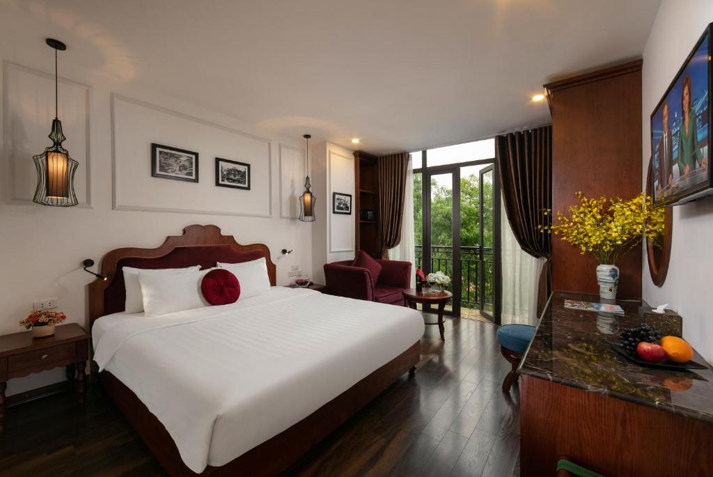1 dormitorio con 1 cama blanca grande y escritorio en Vision Premium Hotel en Hanoi