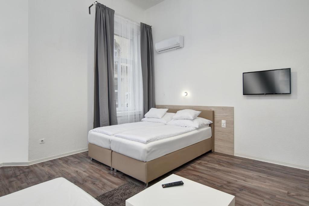 Un dormitorio con una cama y un televisor de pantalla plana. en Heart of Downtown Apartment, en Budapest