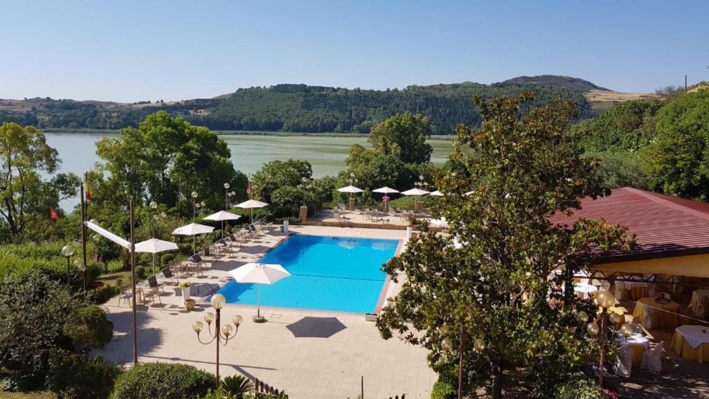 - une vue sur la piscine bordée de parasols et de chaises dans l'établissement Riviera Hotel, à Enna