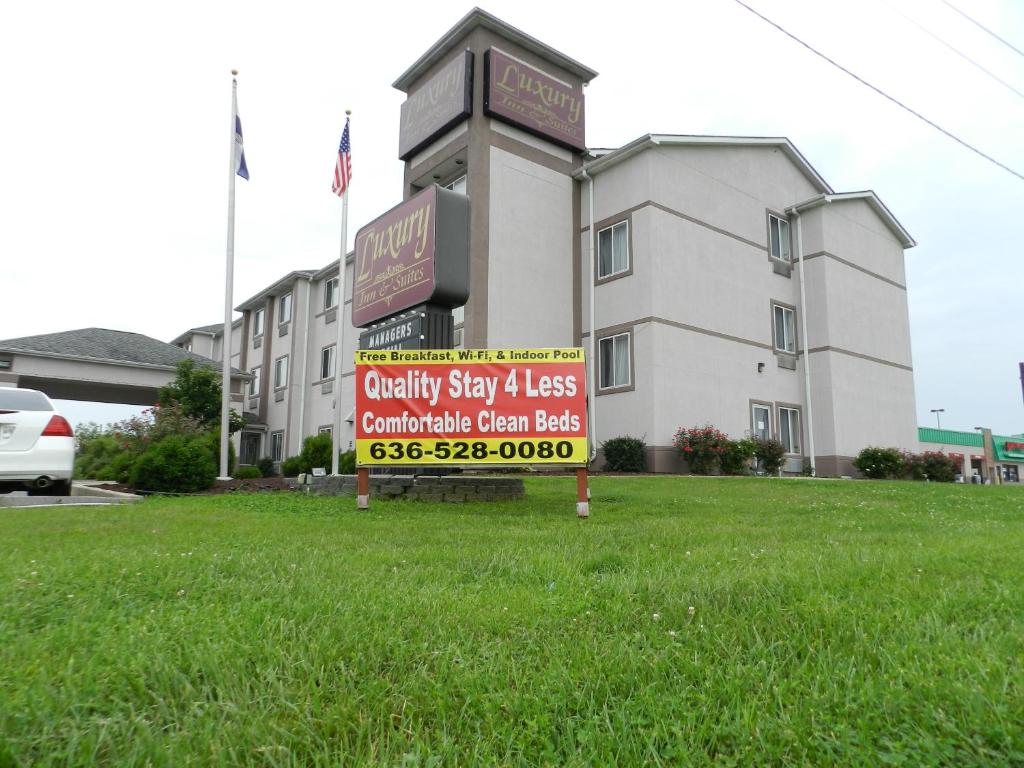 a sign in the grass in front of a building at Luxury Inn & Suites Troy in Troy