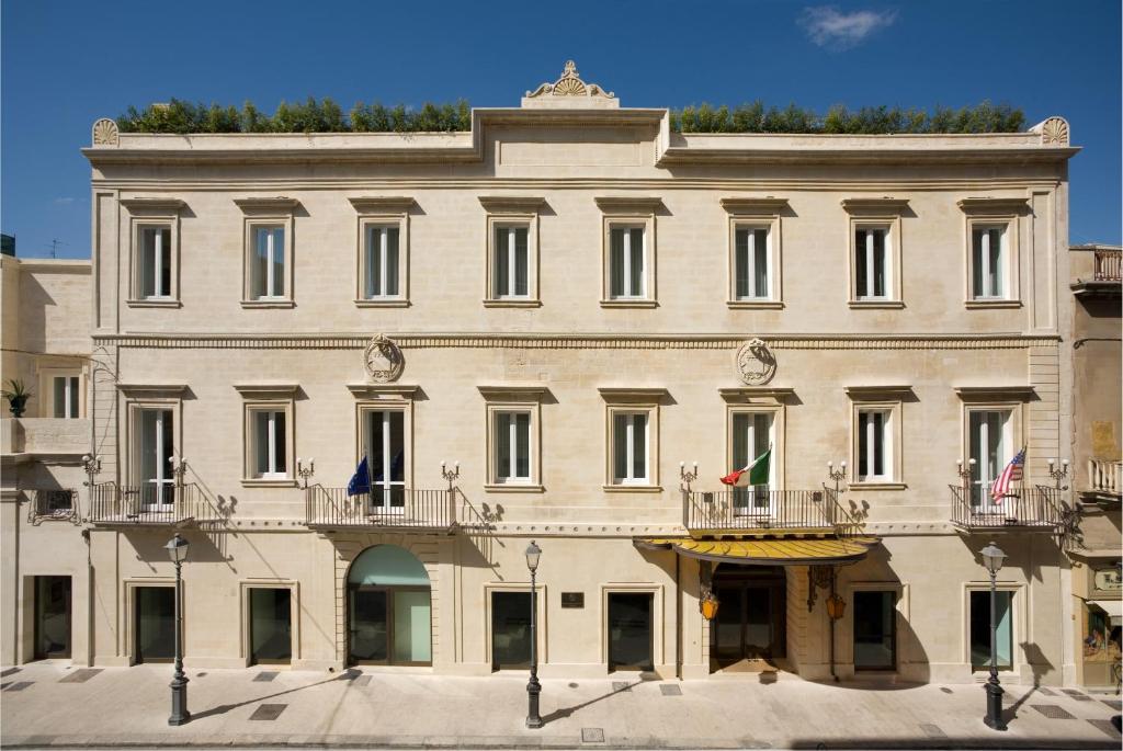 a large white building with two balconies at Risorgimento Resort in Lecce