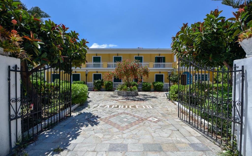 a gate in front of a yellow building at Capriccio Studios in Argassi