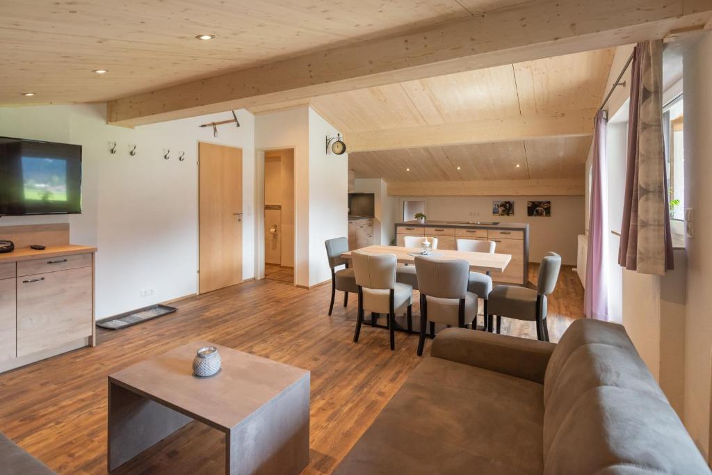 een woonkamer met een bank en een tafel bij Ferienwohnungen stiLECHt in Elbigenalp