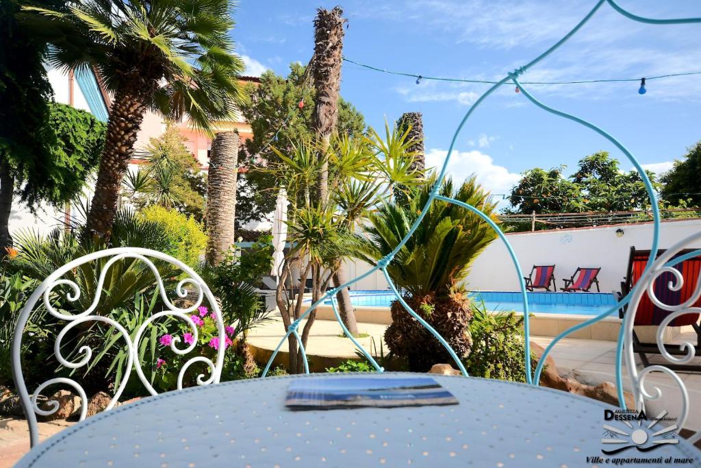 tavolo blu e sedie di fronte alla piscina di Villa Dessena Bed and Breakfast a Cala Liberotto