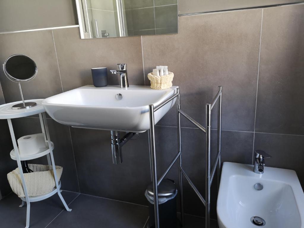 a bathroom with a sink and a mirror and a toilet at Pep's Rooms by the sea in Trieste